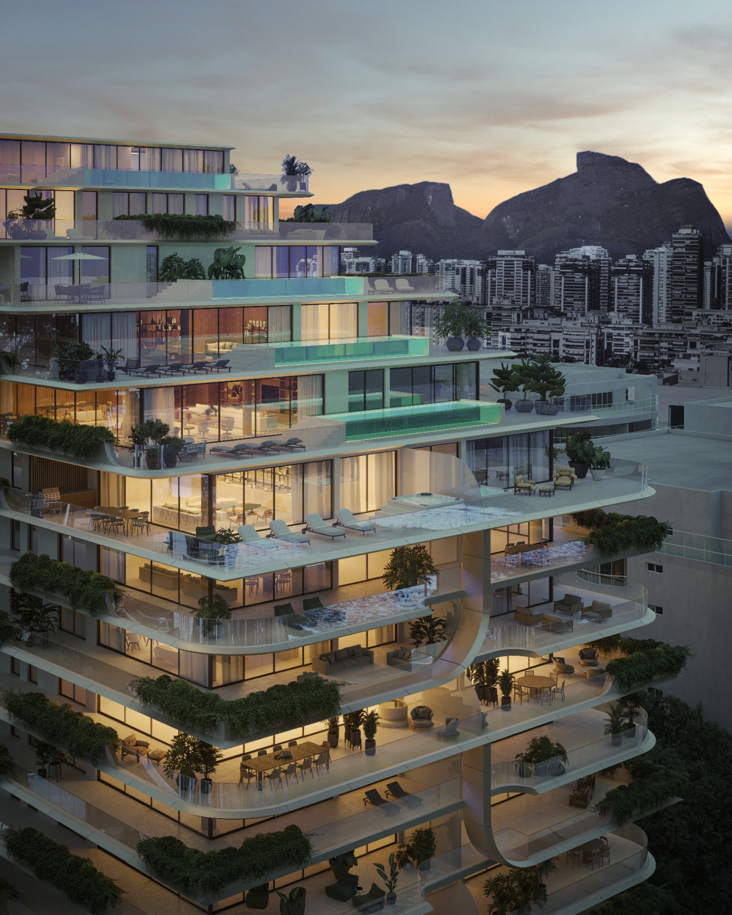 Fachada iluminada ao entardecer com a Pedra da Gávea ao fundo